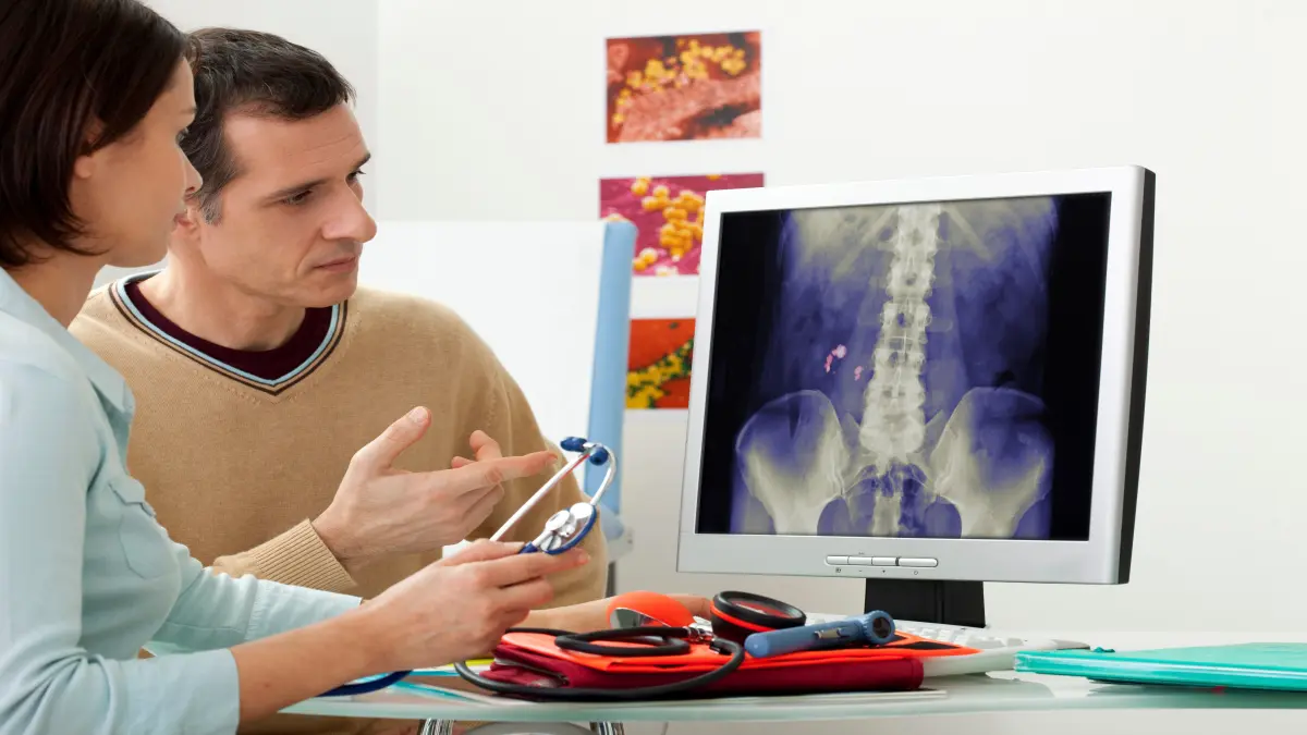 Arzt und Partien vor einem Ultraschallbild