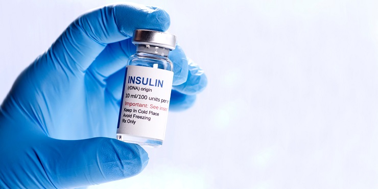 Symbolbild, Insulinvial wird von einer blau behandschuhten Hand gehalten