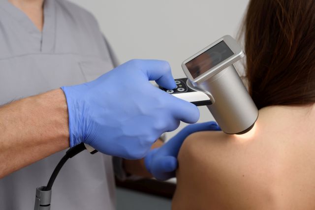 Digitale Dermatoskopie von Muttermalen. Ein Dermatologe-Onkologe untersucht die Muttermale des Patienten mit einem Dermatoskop. Prävention und Früherkennung von Hautmelanomen. Dermatologische Klinik. Nahaufnahme.