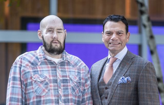 Gesichts- und Augen-transplantierter Patient und sein Arzt