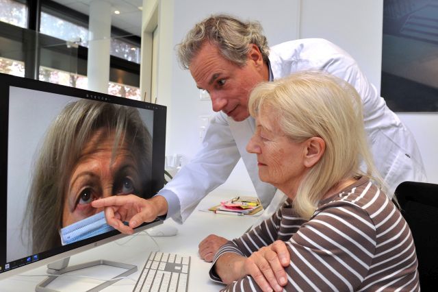 Arzt erklärt Patientin einen Befund auf dem Bildschirm