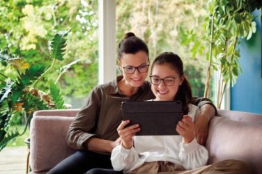 Eine Frau und ein Kind schauen auf ein Tablet