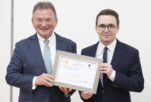 zwei Männer mit Urkunde