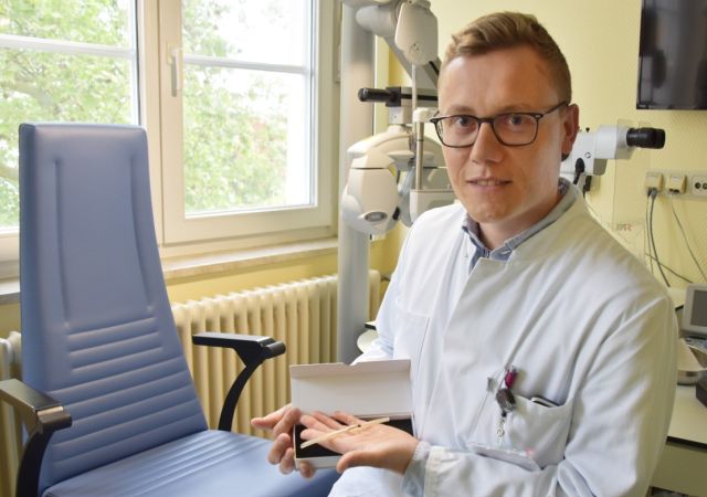 Prof. Brockmann mit einem großen Stentmodell auf der Hand