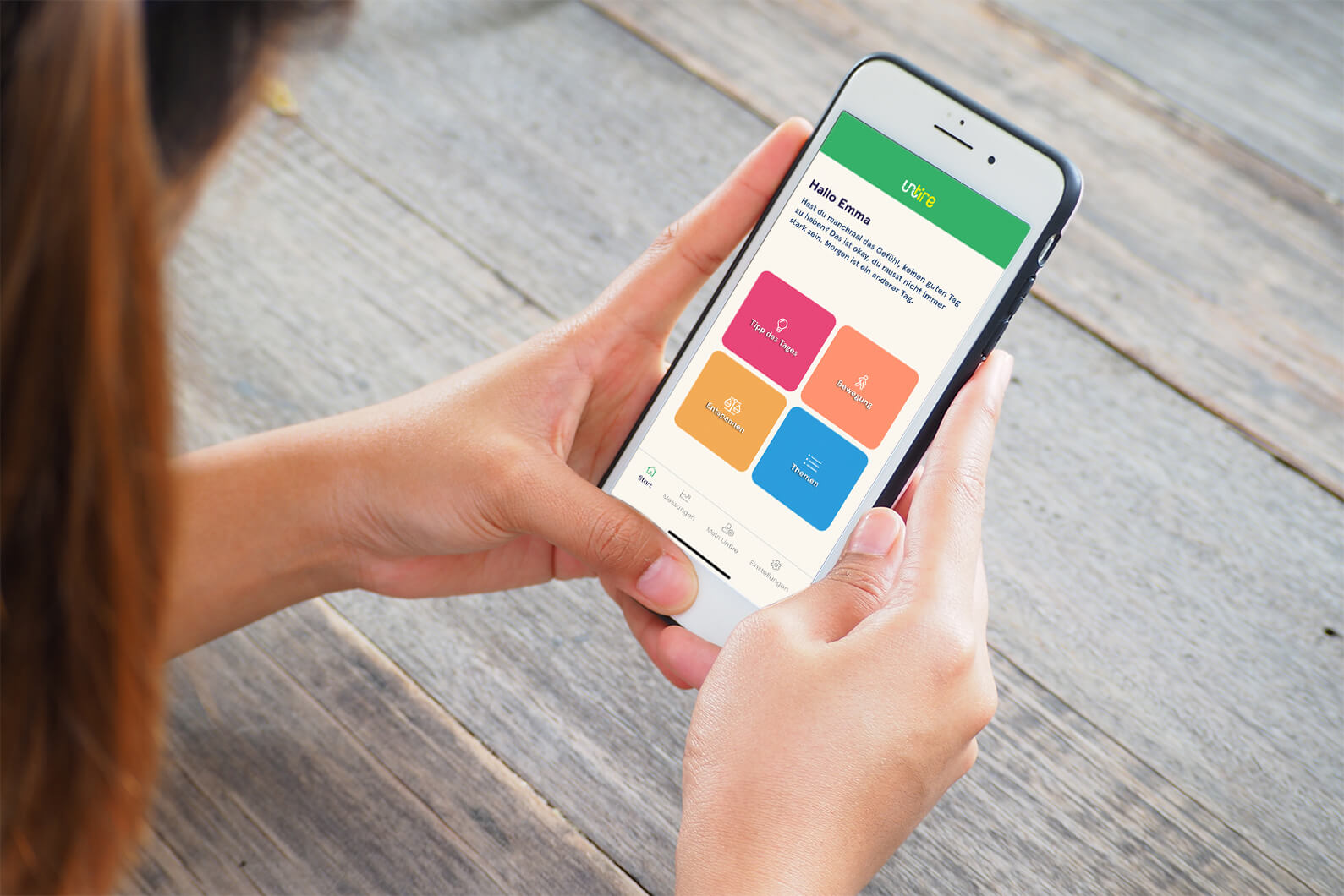 Das Bild zeigt die Hände einer Frau, die ein Handy halten, auf dem die Untire-App geöffnet ist.