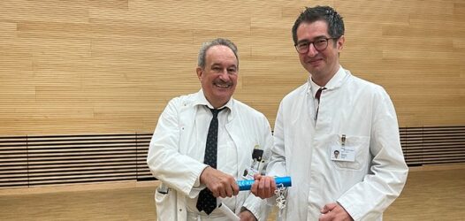 Zu sehen sind ein älterer Herr und ein Mann um die 40 in Arztkitteln. Bildunterschrift: Prof. Jens Rassweiler (l.) ging nach 28 Arbeitsjahren im SLK-Klinikverbund Heilbronn in den Ruhestand und übergab die Klinik an den 42-jährigen PD Dr. Gencay Hatiboglu (r.). (Foto © SLK-Klinikverbund Heilbronn)