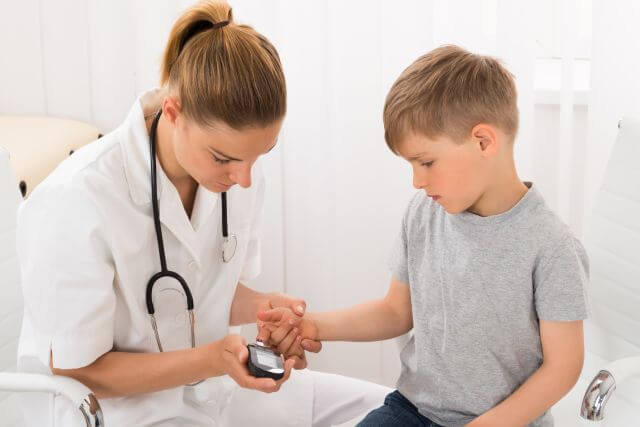 Doctor Examining Blood Sugar Of Little Boy