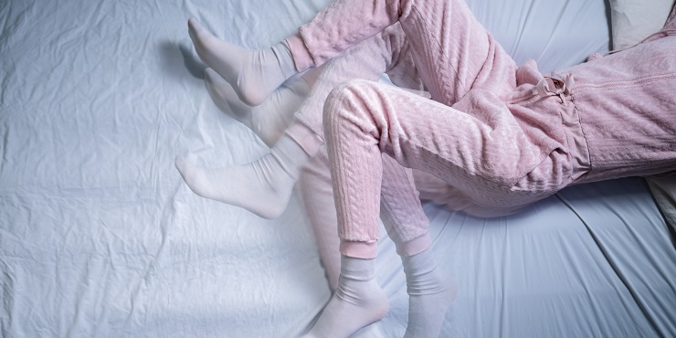 Bewegungen der Beine einer im Bett liegenden Person