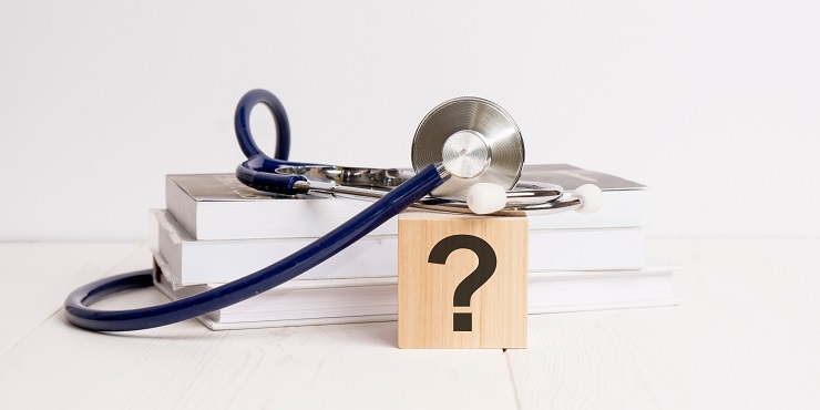 Fragezeichen, Stethoskop und Bücher