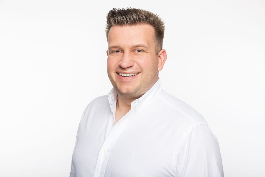 Mann in weißem Hemd vor weißem Hintergrund, Business-Portrait.