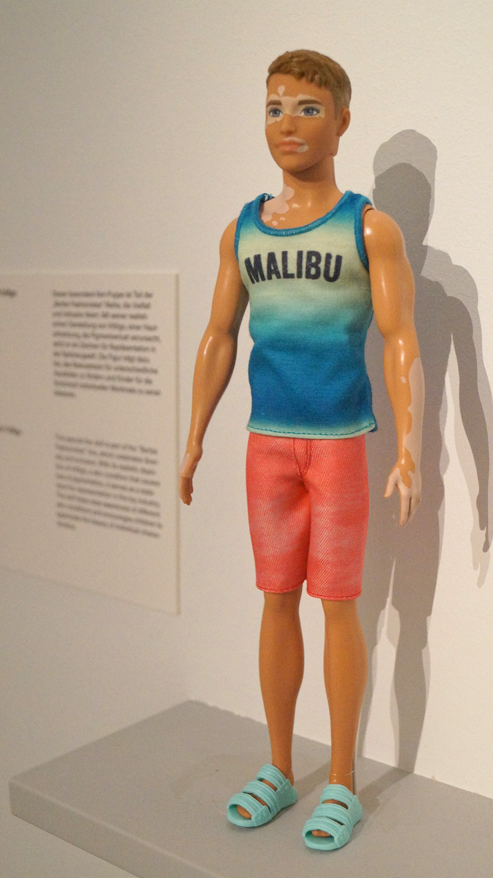 Puppe im Malibu-Design mit buntem Outfit, bestehend aus einem türkisfarbenen Tanktop und roten Shorts.