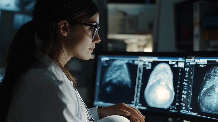 Medizinische Fachkraft analysiert Röntgenbilder auf Monitoren in einem diagnostischen Labor.