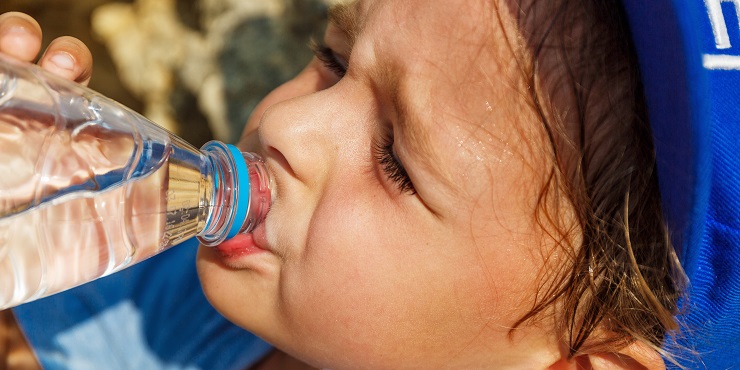 Kleinkind schwitzt und trinkt Wasser