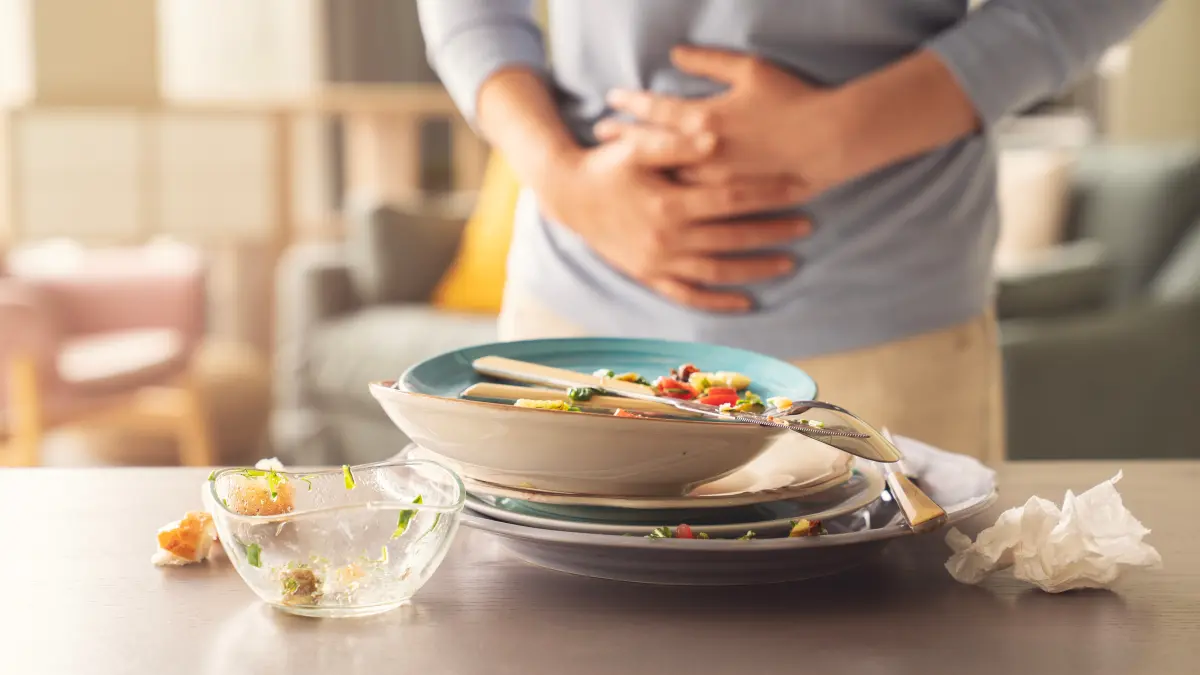 Essen und Frau die sich den Bauch hält