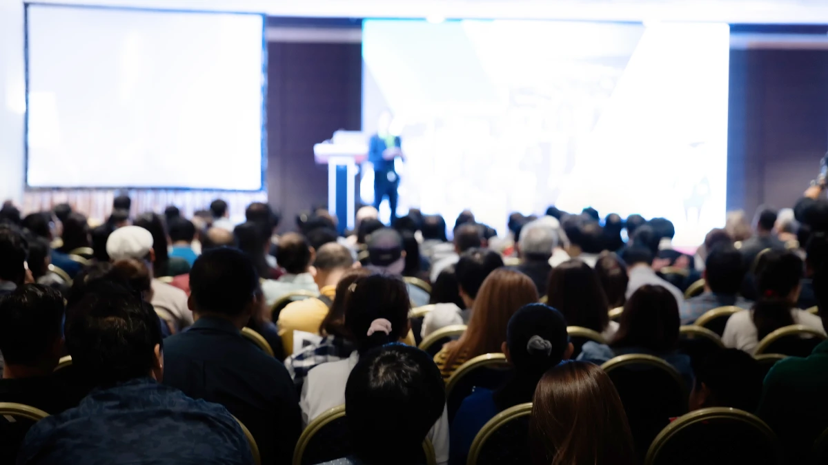 Voller Kongresssaal, vorne wird ein Vortrag gehalten.