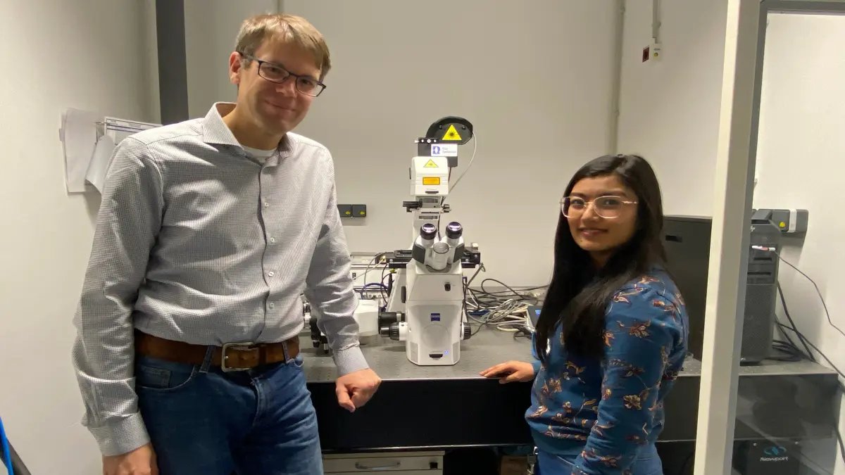 Simon Ebbinghaus und Puja Shrestha untersuchen Proteinbestandteile an einem Mikroskop.
