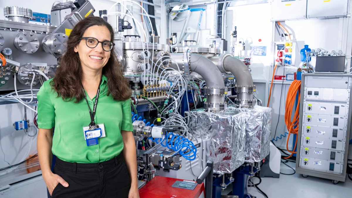 Die Forscherin Ana Diaz steht vor einem riesigen, verkabelten Röntgengerät.