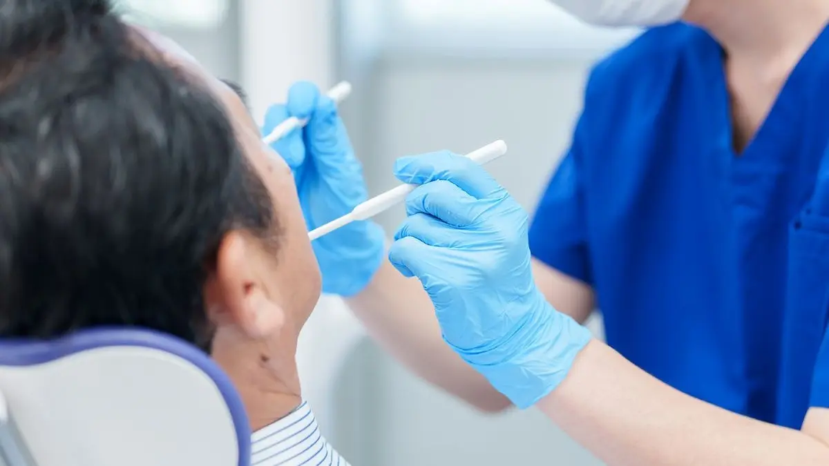 Ein Zahnarzt führt eine Parodontitis-Behandlung bei einem Patienten durch, mit Fokus auf Mundhygiene und Zahnpflege.