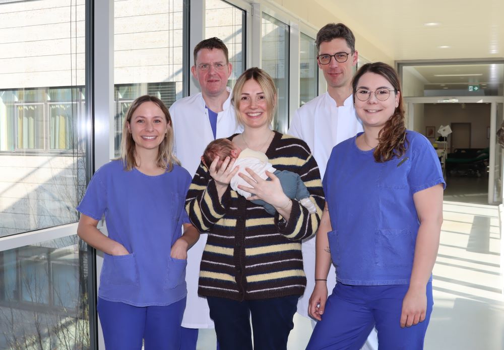 - Gruppenfoto des Behandlungsteams mit Mutter Antonia Krißmer und Sohn Levi. Neben ihnen stehen die Anämie Nurses Lisa Eberle (links) und Karina Reinhard, dahinter Prof. Dr. Peter Kranke (links) und Prof. Dr. Patrick Meybohm. © Annika Wolf / UKW