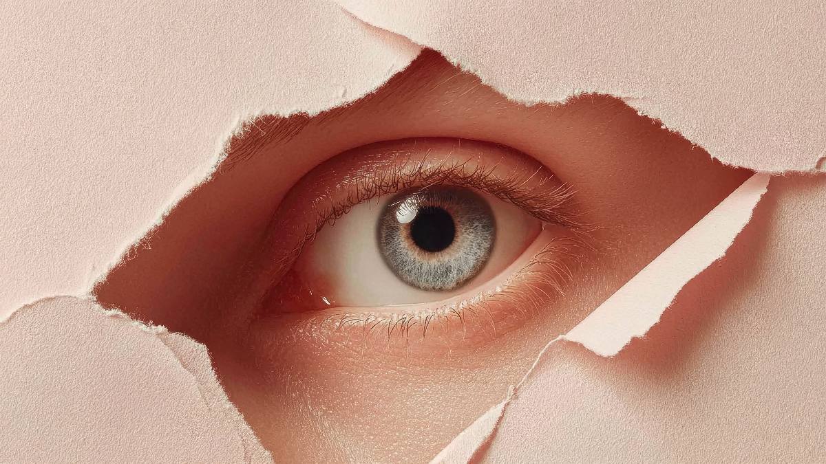 Auge schaut hinter Papier hervor