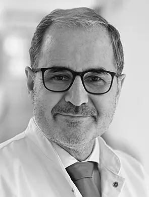 Schwarzweiss-Portraet eines maennlichen medizinischen Experten im Laborkittel