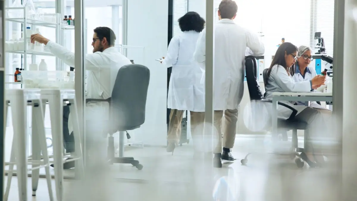 Mehrere Forschende arbeiten in einem modernen Labor an Proben und Analysen als Symbol fuer Studien zu elektronischen PROMs bei der PCa Behandlung