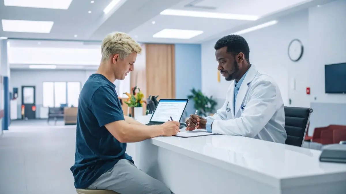 Arzt fuehrt ein Aufklaerungs oder Beratungsgespraech mit einem Patienten und dokumentiert Daten fuer eine medizinische Studie