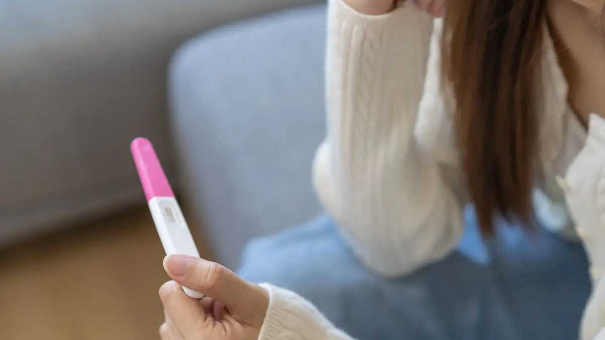 Frau hält negativen Schwangerschaftstest – Isthmozele kann die Fertilität beeinträchtigen.