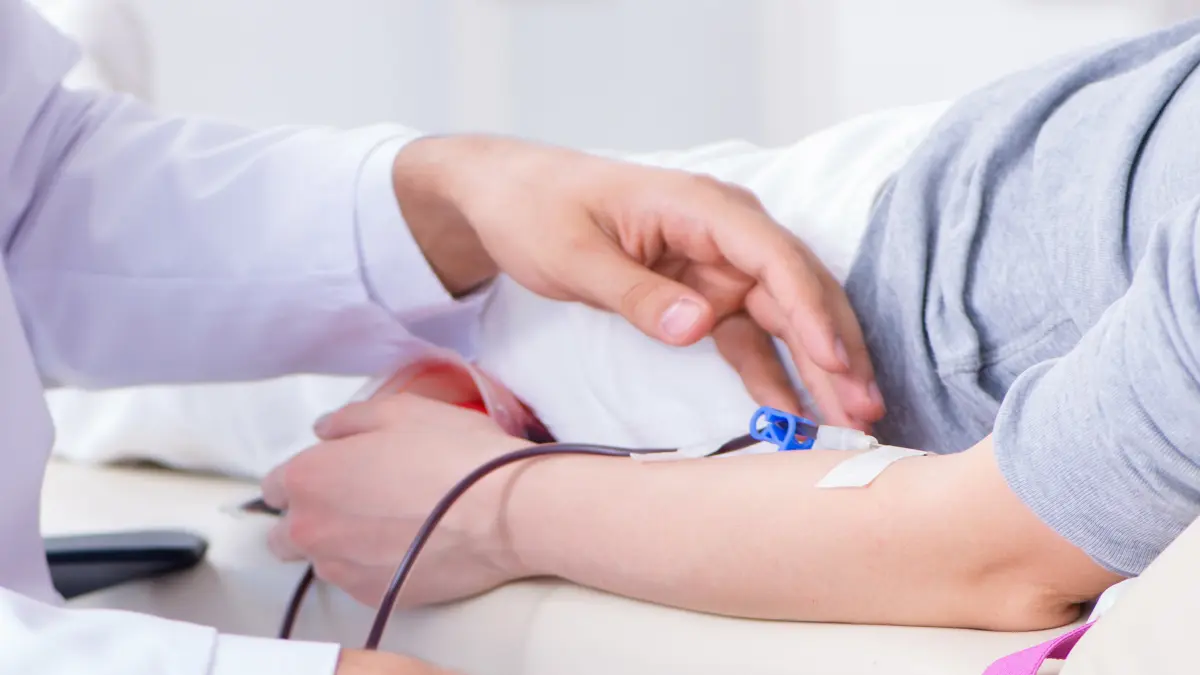 Arzt legt einem Patienten einen intravenösen Zugang am Arm – medizinische Behandlung bei Blutkrebs oder Chemotherapie
