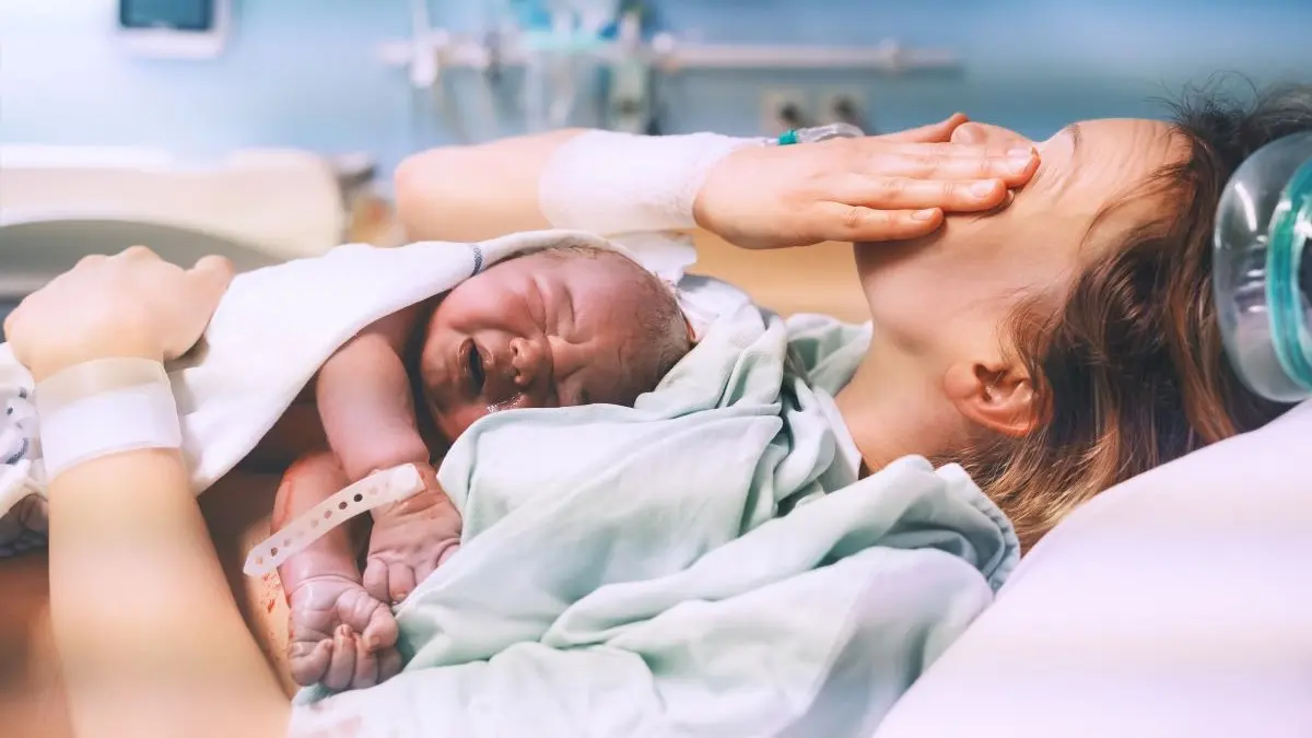 Neugeborenes liegt nach der Geburt auf der Brust der Mutter im Krankenhaus, Symbolbild fuer Geburtseinleitung und zirkadiane Rhythmen