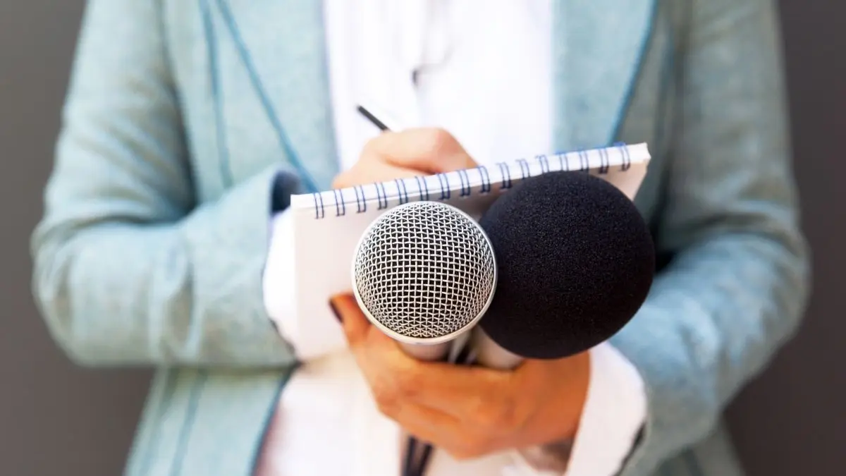 Journalist haelt Mikrofone und Notizblock als Symbol fuer Interview zur fruehzeitigen topischen JAK-Inhibition beim chronischen Handekzem