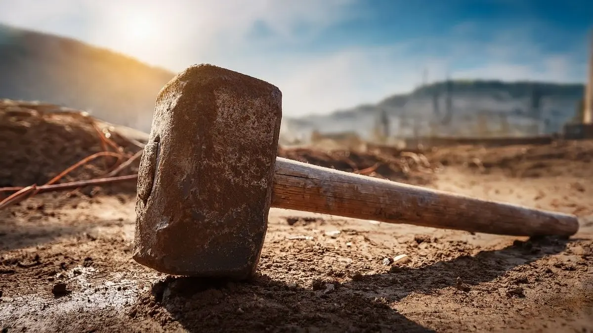 Schwerer Vorschlaghammer auf sonniger Baustelle als Symbol fuer das Hautkrebsrisiko in Outdoor Berufen beim EADV Multi Stakeholder Gipfel zu Hautkrebs