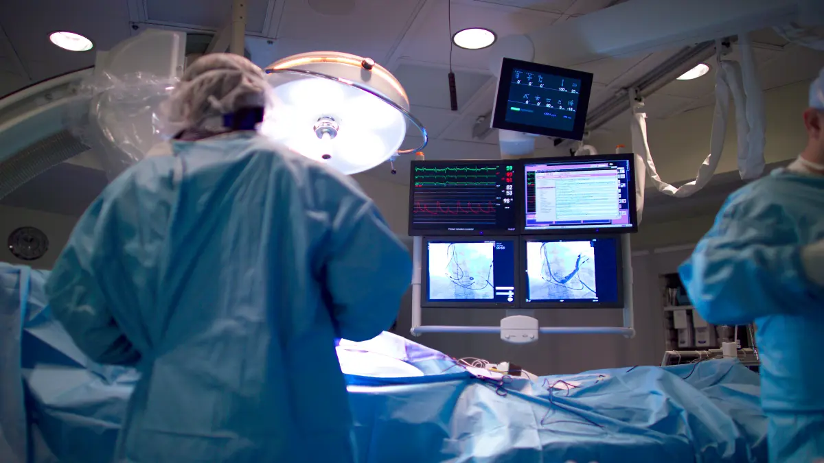 Ärzteteam im Herzkatheterlabor bei einer Katheterablation gegen Vorhofflimmern – Monitore zeigen EKG und Katheter-Bildgebung in Echtzeit