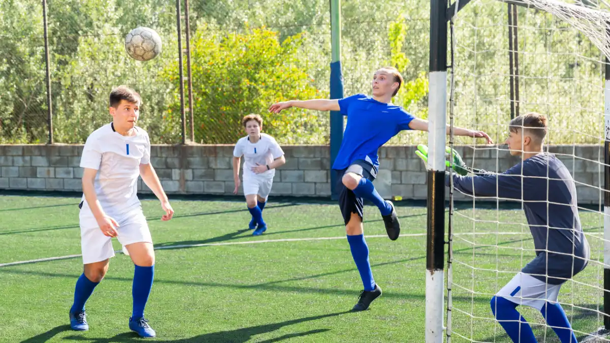 Jugendliche spielen Fußball, ein Jugendlicher macht einen Kopfball