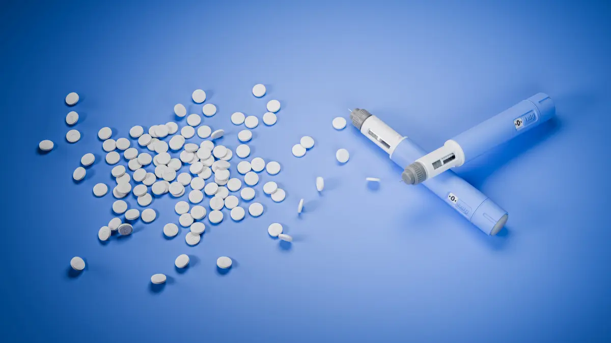 Weiße Tabletten neben zwei blauen Injektionspens – orale und subkutane Semaglutid-Therapie im Vergleich
